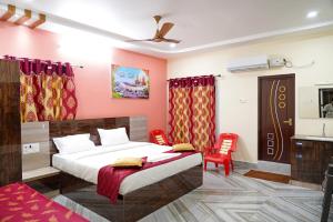 斯里卡拉哈斯蒂Devansh Bhanu Residency DBR的一间卧室配有一张床和两张红色椅子