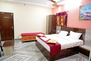 斯里卡拉哈斯蒂Devansh Bhanu Residency DBR的卧室配有一张床铺,位于一间粉红色墙壁的房间
