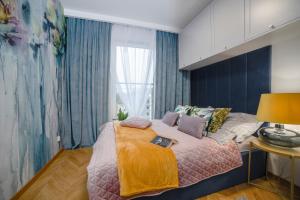 奥尔什丁Apartament Warmiński by RENT4YOU的一间卧室设有一张大床和一个窗户。