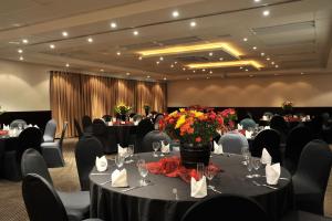 勒斯滕堡Safari Hotel & Convention Centre的宴会厅配有桌椅和鲜花