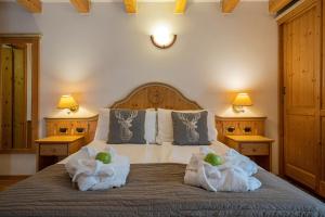坎皮泰洛迪法萨Hotel Soreghes Gran Chalet的一间卧室配有带毛巾的床