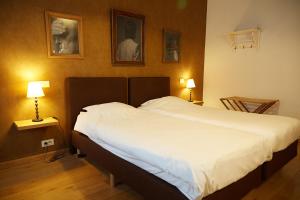 科特赖克Focus Hotel的一间卧室配有一张带两盏灯的大型白色床。
