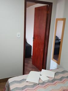 巴拉迪圣若昂Quitinete -Tamoios - Cabo Frio的一间卧室配有一张床、镜子和门