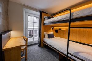 威拉尔-苏-罗伦Villars Lodge的客房设有两张双层床和一扇窗户。