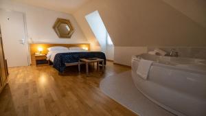 布勒Hôtel du Cheval Blanc - City center的一间卧室配有一张床、一个浴缸和一个浴缸