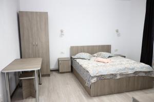 阿雷富Hățașul Bunicului的一间卧室配有一张床、一张桌子和一张桌子