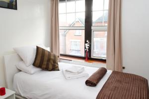 莱斯特Campbells Guest House的卧室配有白色的床和窗户。
