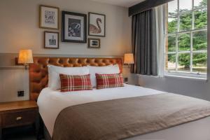 温莎海利校长会议博蒙特庄园酒店的一间卧室设有一张大床和一个窗户。