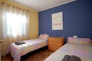 萨洛La Casa del Bosc, playa y golf - Salou的一间卧室设有两张床和窗户。