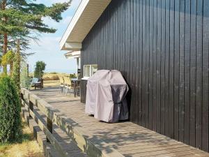 诺德堡6 person holiday home in Nordborg的房屋内带桌椅的木制甲板