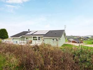 诺德堡6 person holiday home in Nordborg的田野顶部有太阳能屋顶的房子
