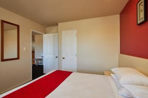 凯库拉罗博思特汽车旅馆的卧室配有白色的床和红色的墙壁