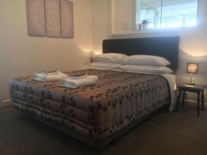 吉斯伯恩Gisborne Dream Suite的一间卧室配有一张床,上面有两条毛巾