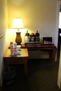 Goldendale戈尔登品质套房酒店的一张桌子,放在酒店房间里,上面有灯