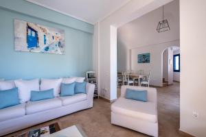 卡马利Santorini Mystique Garden Villa的客厅配有白色沙发和蓝色枕头。