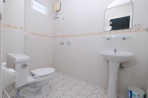 芭东海滩Kiwi Boutique Hotel的白色的浴室设有卫生间和水槽。