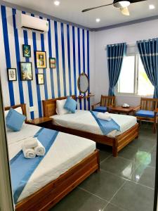 富国BIỂN ĐỒI Bungalow的蓝色和白色条纹间内的两张床