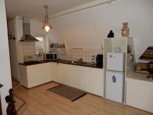 哈林亨Het Speijerhuis的厨房配有白色橱柜和白色冰箱。