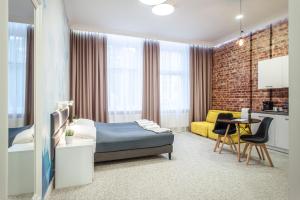 克维曾Gruda Apartments, ŚNIADANIA, Bezpłatny Parking, Faktury VAT的一间卧室配有一张床和一张黄色的沙发