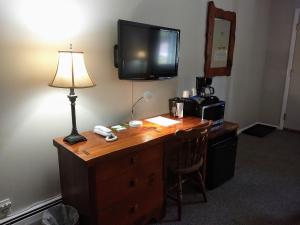 NewfaneThe Lodge at West River的一张桌子,上面有台灯,墙上有一台电视