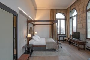莱昂Parador de Turismo de León的一间卧室配有一张天蓬床和一架钢琴
