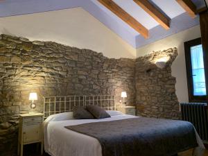 NavasaCaserío de Fatás的卧室配有一张石墙内的大床