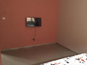 拉各斯Elstine’s的卧室设有壁挂式电视和床。
