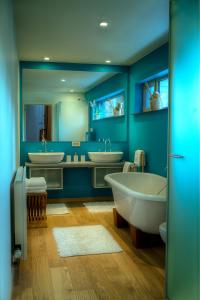 伊普尔Menin Gate House的蓝色浴室设有两个水槽和两个浴缸