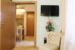 克拉古耶瓦茨帕拉迪索斯公寓的客厅配有椅子和墙上的电视