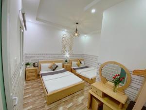 大叻Dalat Hills Hotel的一间设有两张床的房间,内设一张长凳