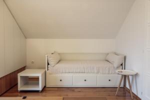 ŠarengradRural House Veranda的白色的房间里,有一张白色的床,有凳子