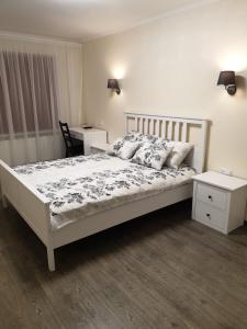 古尔贝内Swan City Apartment的卧室配有白色的床、桌子和书桌