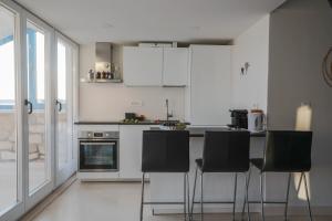 赫瓦尔Penthouse in old Dalmatian house - Flybridge的厨房配有白色橱柜和黑色椅子