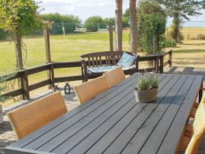 诺德堡6 person holiday home in Nordborg的一张带椅子和长凳的木制野餐桌