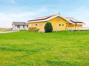 诺德堡8 person holiday home in Nordborg的绿草丛中的黄色房子