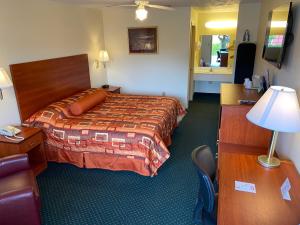 尤宁城Country Hearth Inn-Union City的酒店客房配有一张床和一张带台灯的书桌