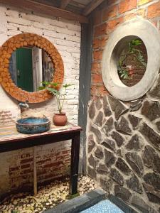 日惹阿朱那花园民宿的一间带镜子和石墙的浴室