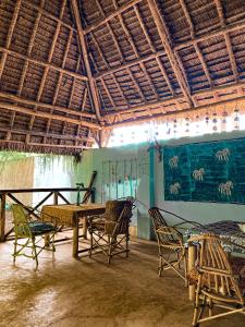 基济姆卡济Mawingu lodge的一间带椅子和桌子的房间以及天花板