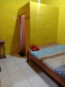 茂物Penginapan Dinafizka的一间设有床和黄色墙壁的客房