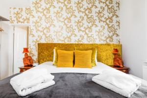 朴次茅斯Ashbys Accommodation & Spa hire的一间卧室配有一张带黄色床头板的大床