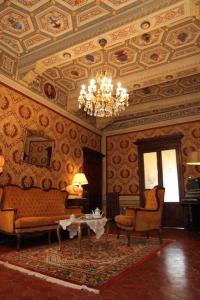 丘西Residenza Dei Ricci的客厅配有沙发、椅子和吊灯
