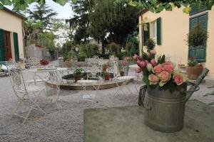 丘西Residenza Dei Ricci的院子里的一桶鲜花,有桌椅