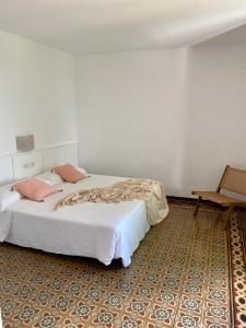 帕拉莫斯Ecoturisme Mas Ribas的卧室配有一张白色大床和一把椅子