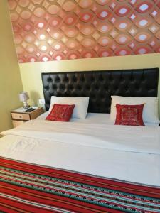 安曼哈穆达酒店的卧室配有带红色枕头的大型白色床