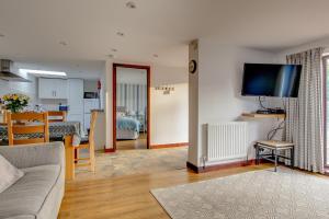 FelbriggAnvil & Stable Cottages的客厅配有沙发和墙上的电视