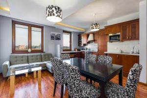 波兹南Sleepway Apartments- Szyperska的厨房以及带桌椅的起居室。