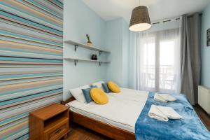 波兹南Sleepway Apartments- Szyperska的一间卧室配有一张带彩色墙壁的床
