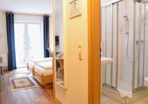 吕贝克特威豪斯加尼森林酒店的带淋浴、盥洗盆和镜子的浴室