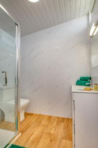 FelbriggThe Covey的一间铺有木地板的白色墙壁浴室