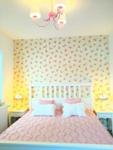 蒂蒂湖-新城Romantic Style Apartment Titisee-Neustadt的一间卧室配有粉红色的床和两张桌子